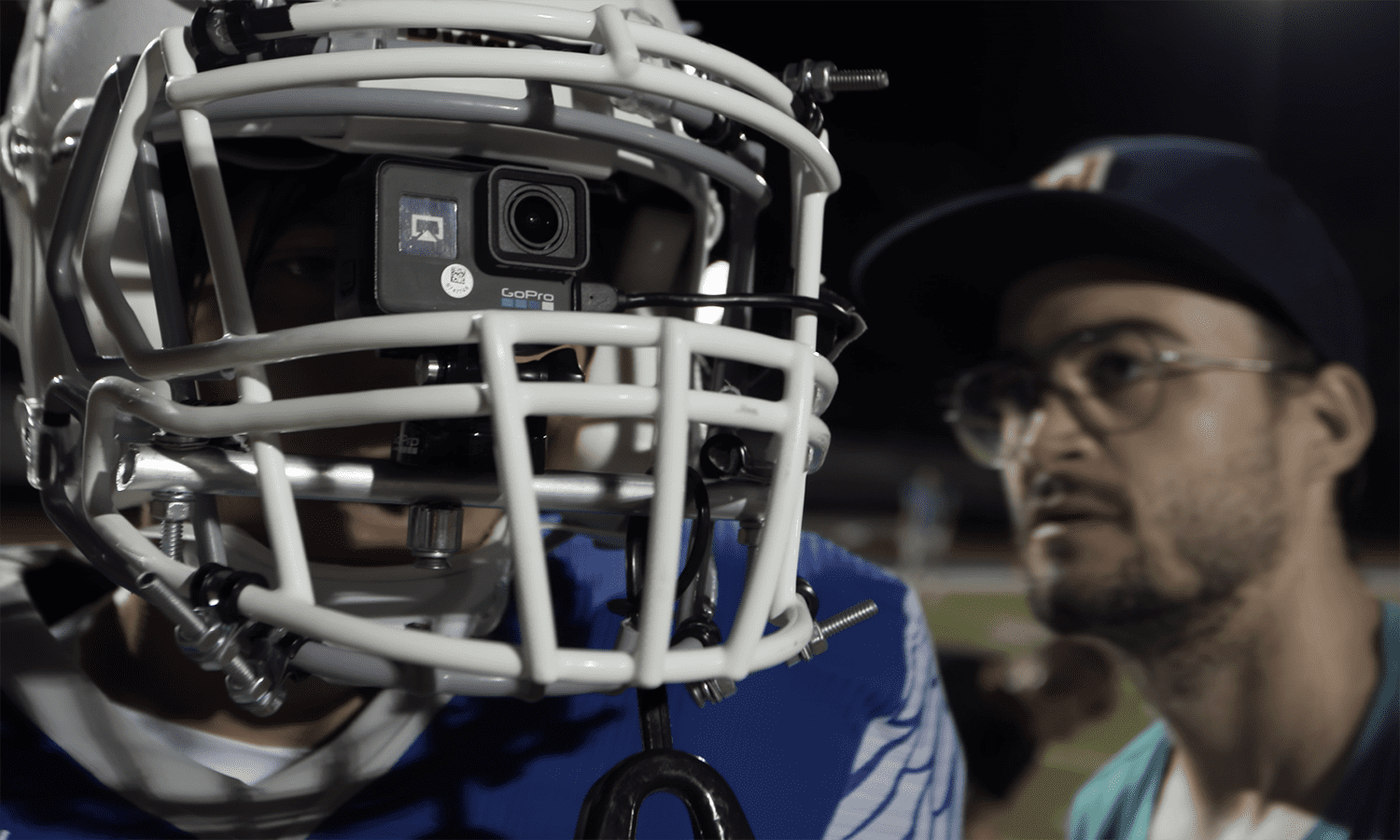 Cameraman checks go pro mounted on football player's helmet